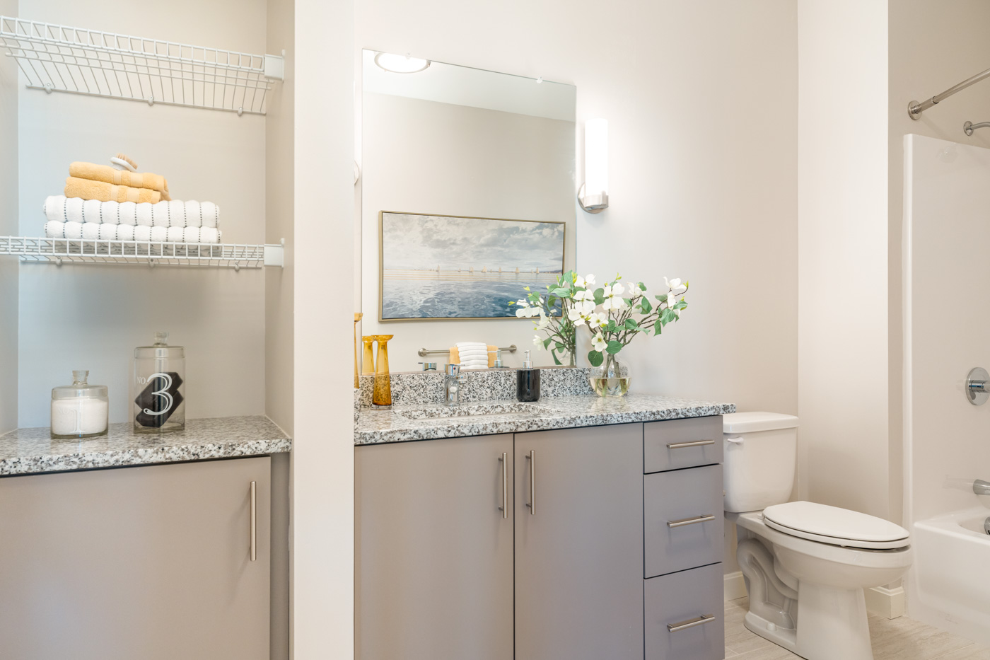 One bedroom bathroom with gray cabinets